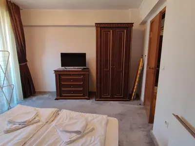a bedroom with a bed and a television on a dresser at Snowy tale in Pamporovo