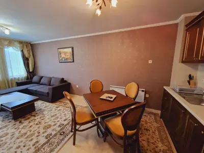 a living room with a table and chairs and a couch at Snowy tale in Pamporovo