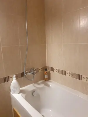 a bathroom with a bath tub with a sink at Pirin Golf Guest Room in Razlog
