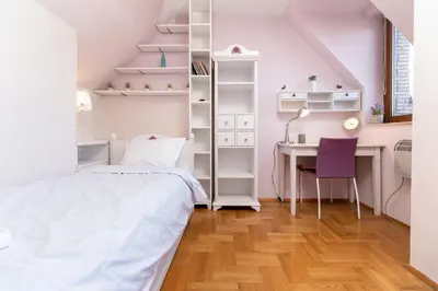 a bedroom with a bed and a desk with a chair at Penthouse Tepeto in Plovdiv