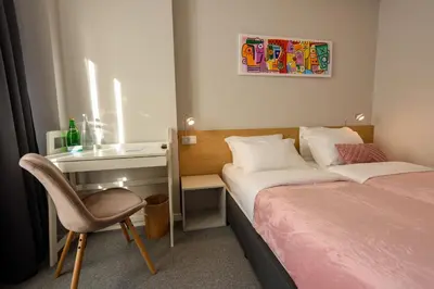 a bedroom with two beds and a desk and a chair at LOCATION in Sofia