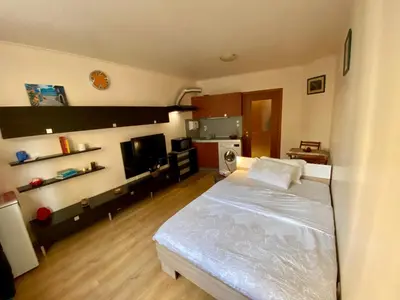 a bedroom with a white bed and a kitchen at Sofia Cozy Retreat in Sofia