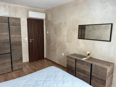 a bedroom with a bed and a mirror on the wall at Апартамент Комфорт 2 Близо до Летището in Sofia