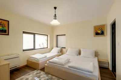 a bedroom with two beds and a window at ВИЛА МАРИНОВИ in Boykovo