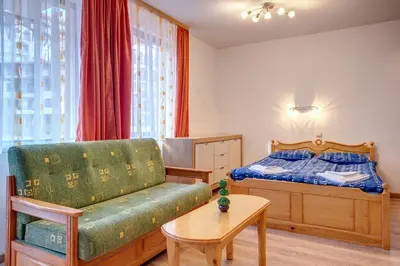 a bedroom with a bed and a couch and a table at Cozy Studio in Hotel Laplandia, Pamporovo by Flat Mаnager in Pamporovo