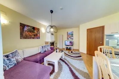 a living room with a purple couch and a table at 1BD Ski View Retreat in Pamporovo with Fireplace by Flat Mаnager in Pamporovo