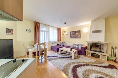 a living room with a purple couch and a fireplace at 1BD Ski View Retreat in Pamporovo with Fireplace by Flat Mаnager in Pamporovo