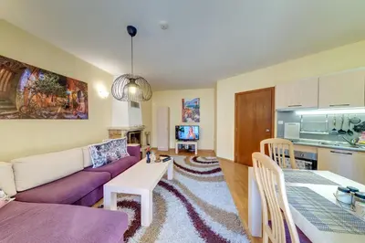 a living room with a purple couch and a table at 1BD Ski View Retreat in Pamporovo with Fireplace by Flat Mаnager in Pamporovo