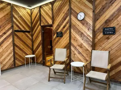 a room with two chairs and a clock on a wall at Sana Ski apartment 313A in Flora, Borovets in Borovets