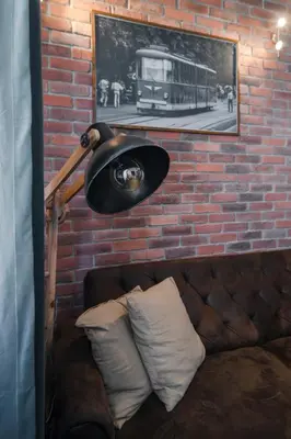 a lamp sitting next to a brick wall with a couch at Designer 1BD Cinématique on Solunska by Flat Mаnager in Sofia