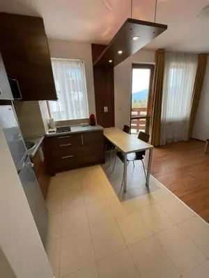 a kitchen with a wooden table and a table and a dining room at Belvedere Holiday Club ,apartment A202 in Bansko