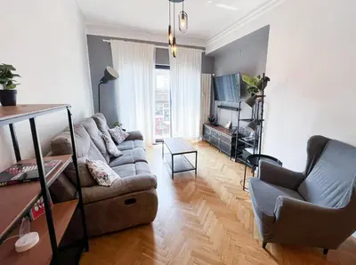 a living room with a couch and a tv at Perfect Long-term Stay Stylish and Spacious Top Center Next to Vitosha Blvd in Sofia