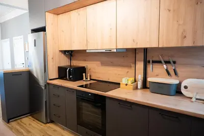 a kitchen with wooden cabinets and a counter top at Perfect Long-term Stay Stylish and Spacious Top Center Next to Vitosha Blvd in Sofia