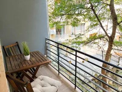 a balcony with a bench and a table and a tree at Perfect Long-term Stay Stylish and Spacious Top Center Next to Vitosha Blvd in Sofia