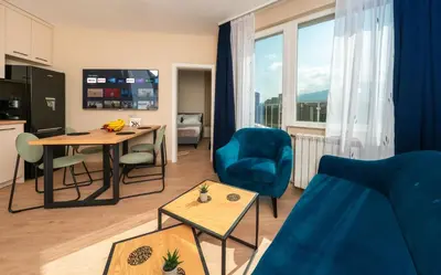 a living room with a blue couch and a table at Modern Maisonette - 2 Bedrooms - Terrace - Vitosha View in Sofia