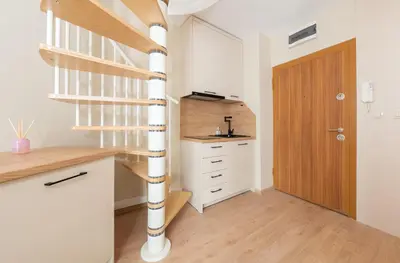 a spiral staircase in a small room with a wooden door at Modern Maisonette - 2 Bedrooms - Terrace - Vitosha View in Sofia