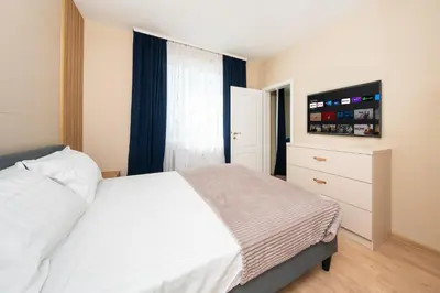 a bedroom with a white bed and a television at Modern Maisonette - 2 Bedrooms - Terrace - Vitosha View in Sofia
