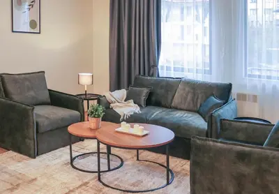 a living room with a couch and a table at Antonovi Apartments Deluxe in hotel Laplandia in Pamporovo