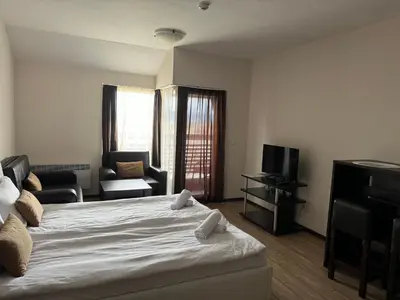 a bedroom with a bed and a living room at Alpine Lodge Bansko Apartments in Bansko