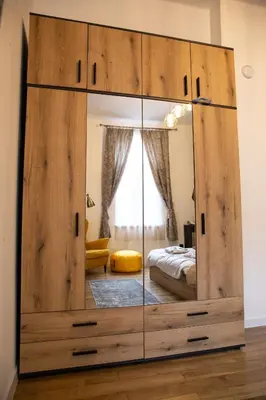a large wooden cabinet with a mirror in a bedroom at Apartment Serdika 1 in Sofia