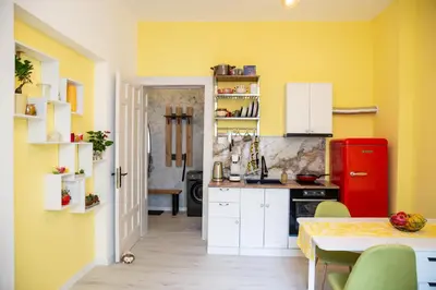 a kitchen with yellow walls and a red refrigerator at Apartment Serdika 1 in Sofia
