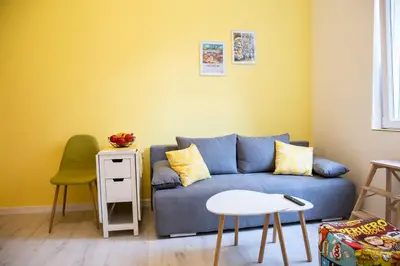a living room with a blue couch and a table at Apartment Serdika 1 in Sofia