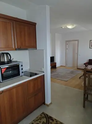 a kitchen with a microwave and a living room at Gondola lift apartment 5401 in Bansko