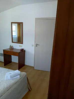 a bedroom with a bed and a desk and a mirror at Gondola lift apartment 5401 in Bansko