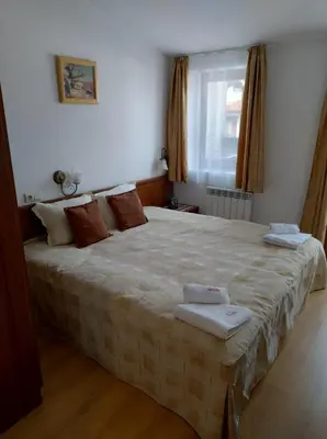 a bedroom with a large bed with two towels on it at Gondola lift apartment 5402 in Bansko