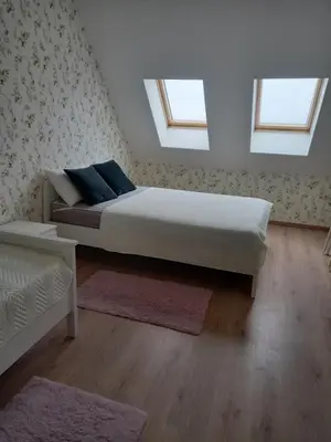 a bedroom with a bed and two windows at апартамент Римската стена in Hisarya