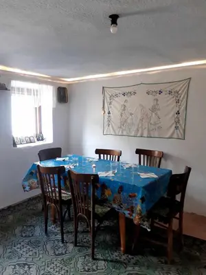 a dining room with a blue table and chairs at Апартамент Стар стил Old style in Raduil