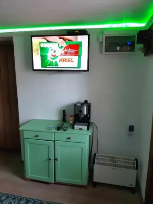 a tv hanging on a wall with a green cabinet at Апартамент Стар стил Old style in Raduil