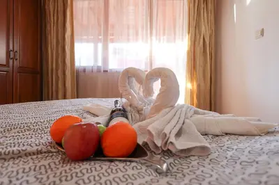 a tray of fruit and towels on a bed at Pirin Golf Mountain View Retreat in Razlog