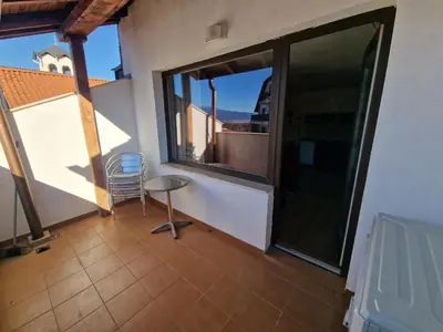 a balcony with a table and a chair on it at Bansko Royal Towers Thea Apartment, modern renovated bathroom in Bansko