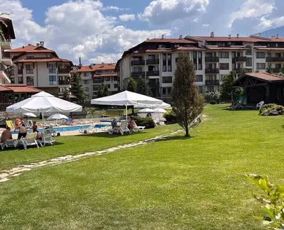 a group of people sitting under umbrellas in a park at Bansko Royal Towers Thea Apartment, modern renovated bathroom in Bansko