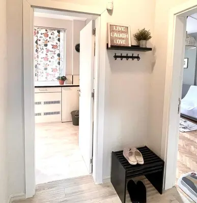 a hallway with a door leading into a room with a table at Dreamy Apartment Near To The Center in Sofia