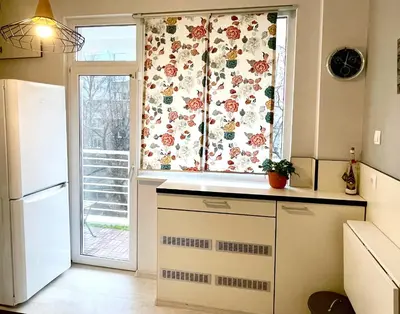 a kitchen with a window with a flower curtain at Dreamy Apartment Near To The Center in Sofia