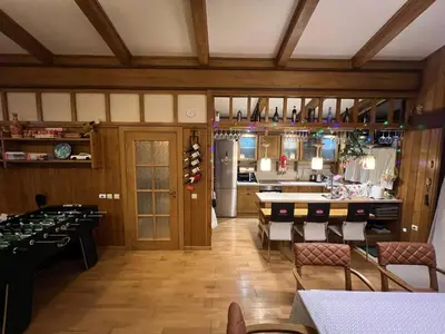 a dining room with tables and chairs and a kitchen at Villa - VALL DI VALL in Pirin Golf & Country Club in Razlog