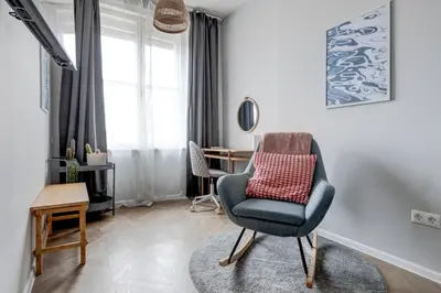 a living room with a chair and a table at Sofia's Elegant Urban Retreat in Sofia