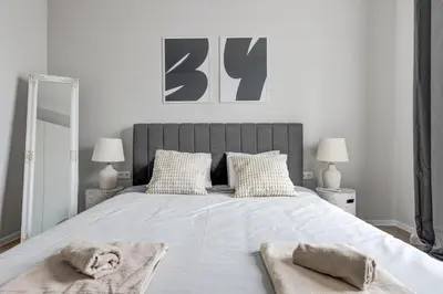 a bedroom with a large bed with two towels on it at Sofia's Elegant Urban Retreat in Sofia