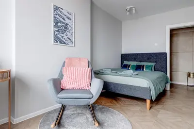a bedroom with a bed and a chair in it at Sofia's Elegant Urban Retreat in Sofia