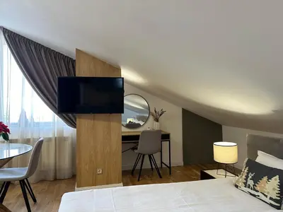 a bedroom with a bed with a television and a desk at Sana Ski apartment 702 in Flora, Borovets in Borovets