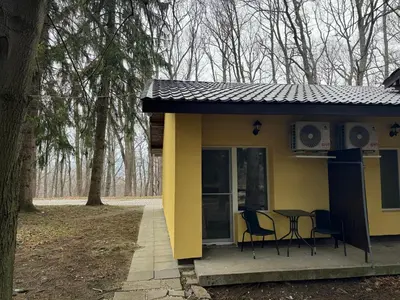 a small yellow house with a table and chairs at Мотел Тихия кът in Sofia