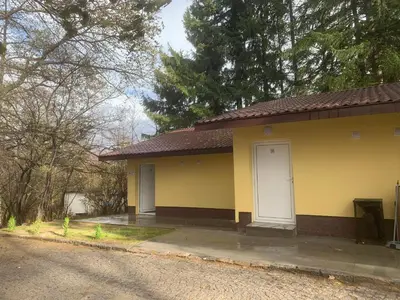 a yellow house with a white door on a street at Мотел Тихия кът in Sofia