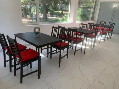a dining room with black tables and red chairs at Мотел Тихия кът in Sofia