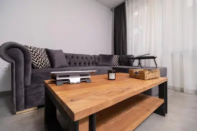 a living room with a couch and a wooden table at Chic 1BR Apartment with Balcony in Plovdiv in Plovdiv