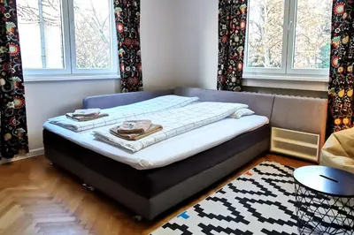 a bed sitting in a room with windows at Beautifully Decorated Functional Apartment in Sofia