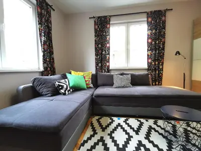 a living room with a couch and two windows at Beautifully Decorated Functional Apartment in Sofia