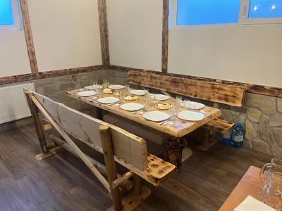 a wooden table with plates and glasses on it at Къща за гости Оскови in Velingrad