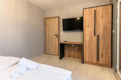 a bedroom with a bed and a desk with a television at Къща за гости Оскови in Velingrad